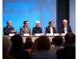 Et panel med kulturelle ledere og motehistorikere diskuterer på en konferanse, med et mangfoldig publikum som lytter intenst.